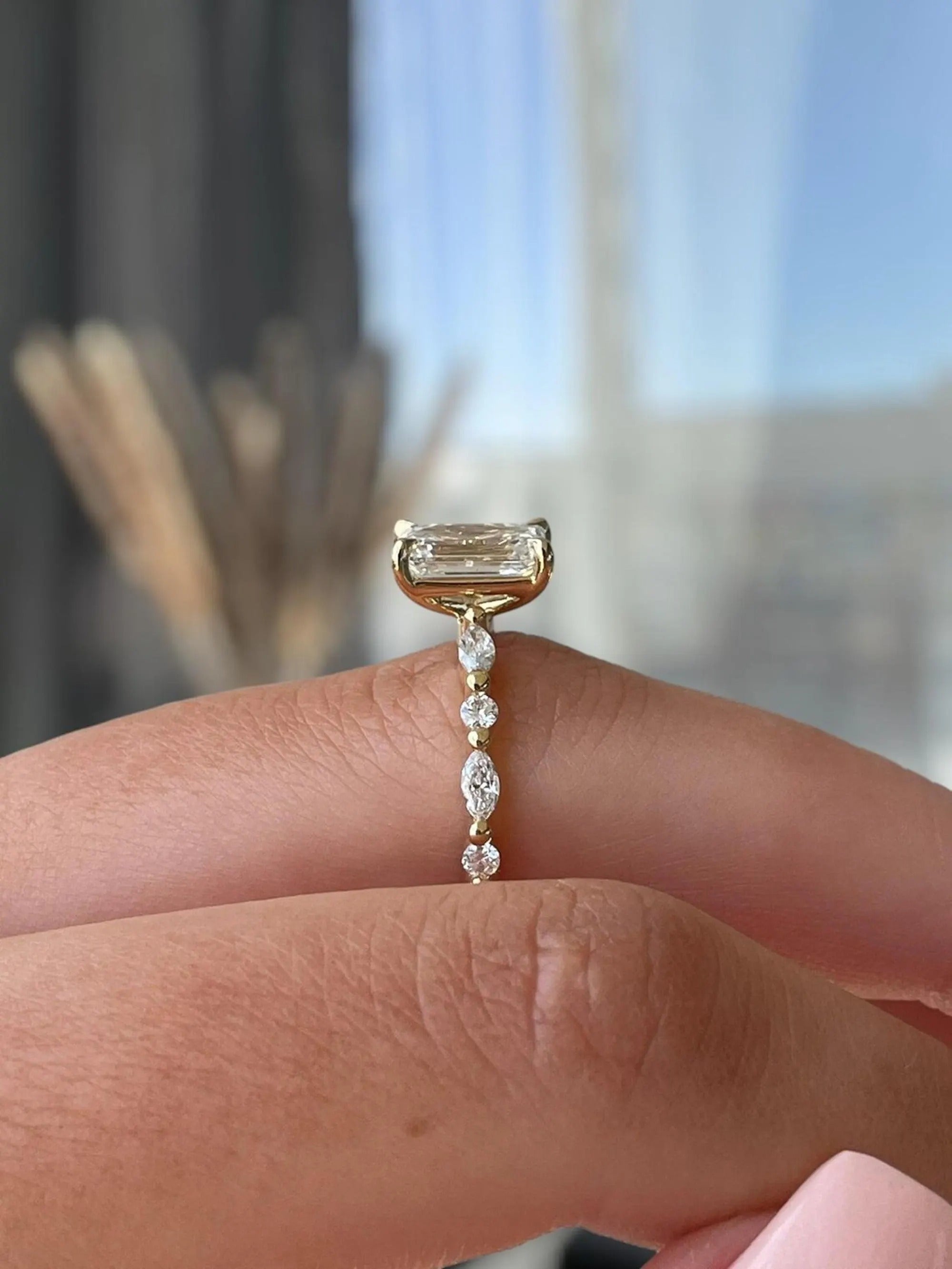 Gold ring with a diamond on a finger against a blurred background