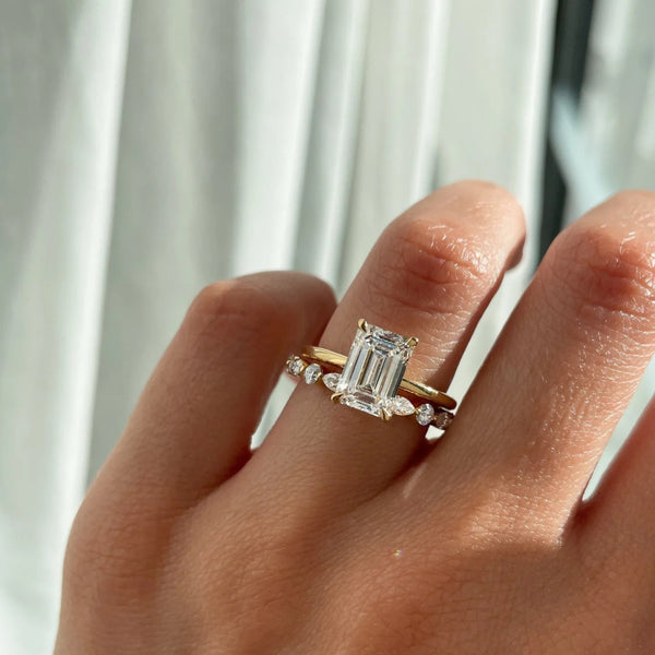 round engagement ring with emerald wedding band